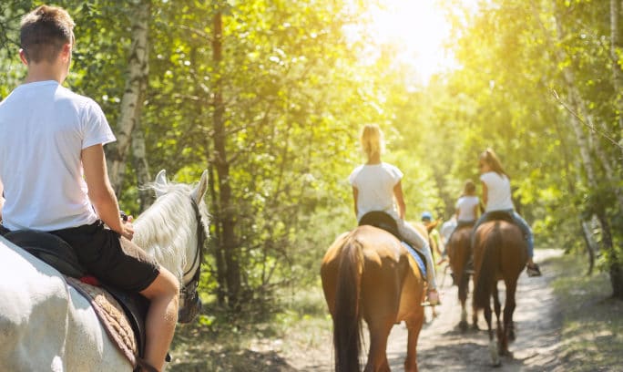 A group of young people enjoying horse back riding