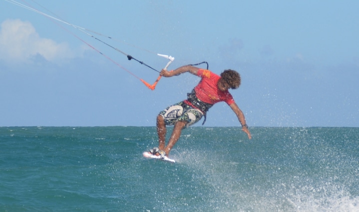 A man kite surfing in the ocean, enjoying the thrill of riding the waves with a colorful kite.